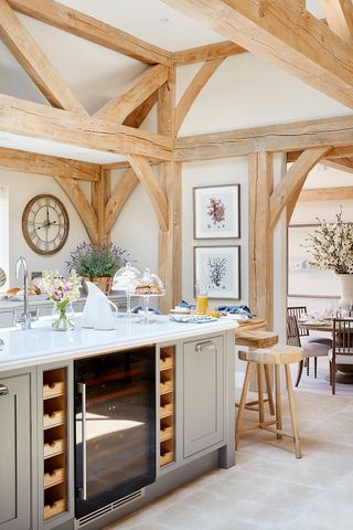 Kitchen with exposed oak beams, large kitchen island and breakfast bar with view through an arch to the dining room.