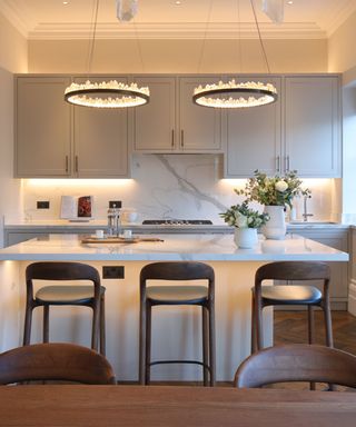 Kitchen with multiple light sources including ceiling lights, under cabinet accent lighting and lighting under the kitchen island