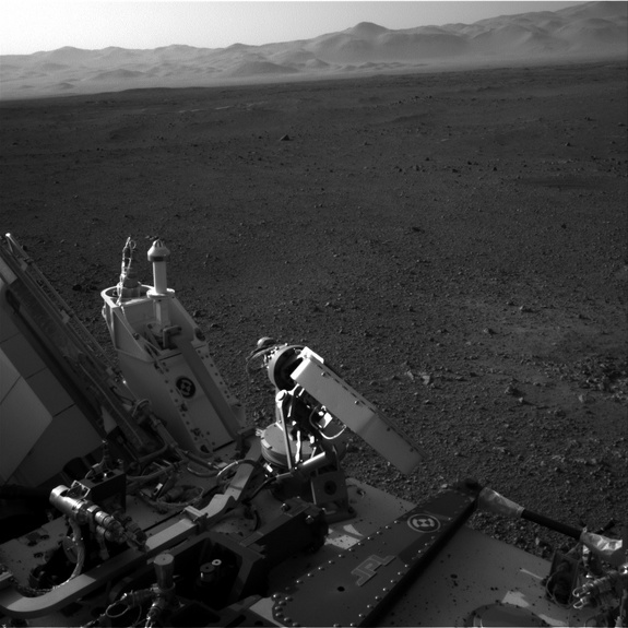 This view shows part of Curiosity rover at bottom with the rim of Gale Crater on Mars in the distance. Image released August 9, 2012.