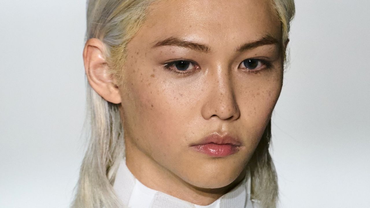 A model with bleached blonde hair and dark eyebrows.