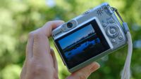 The Canon PowerShot A540 held in a person's hands outdoors