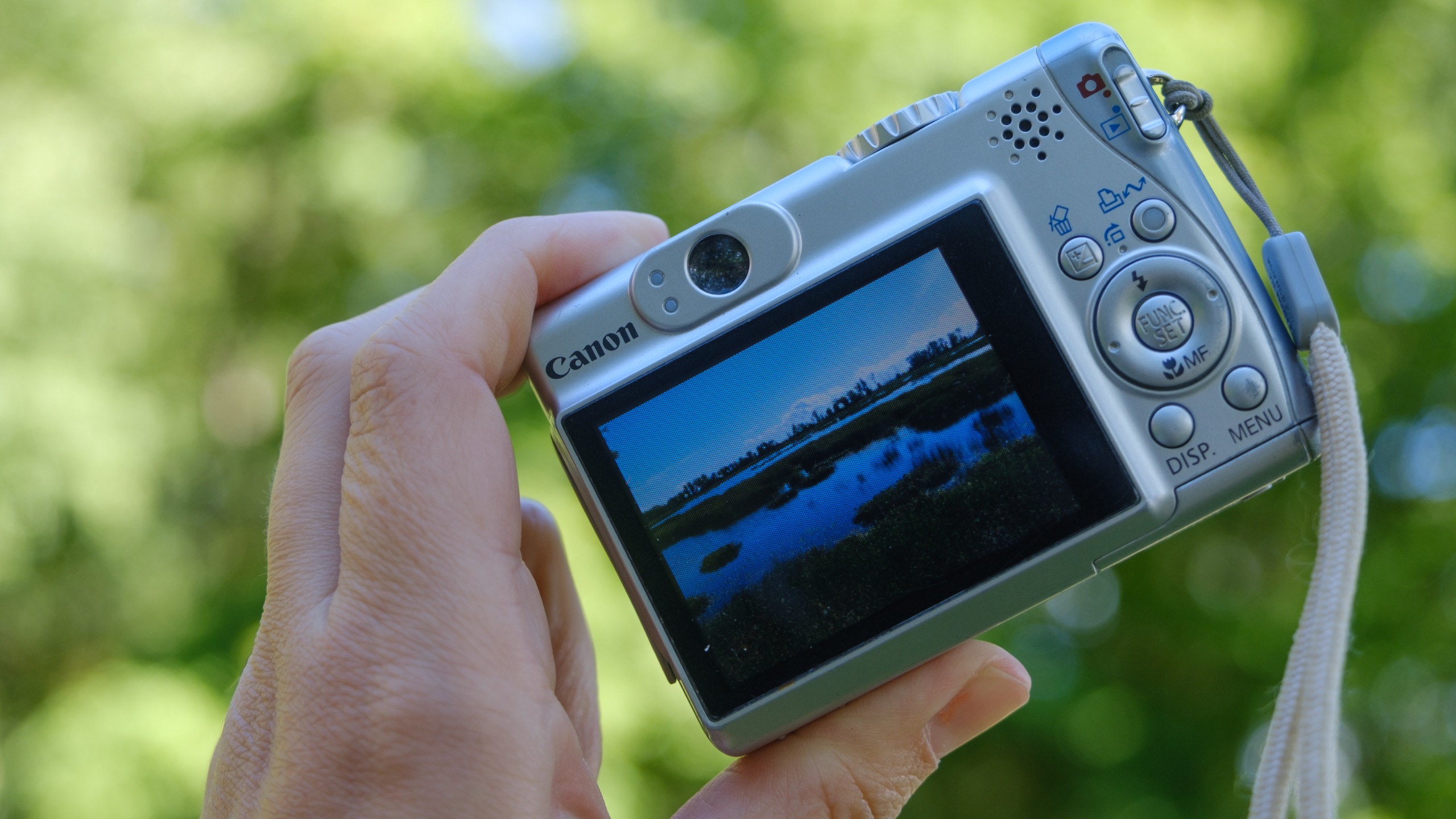 The Canon PowerShot A540 held in a person's hands outdoors