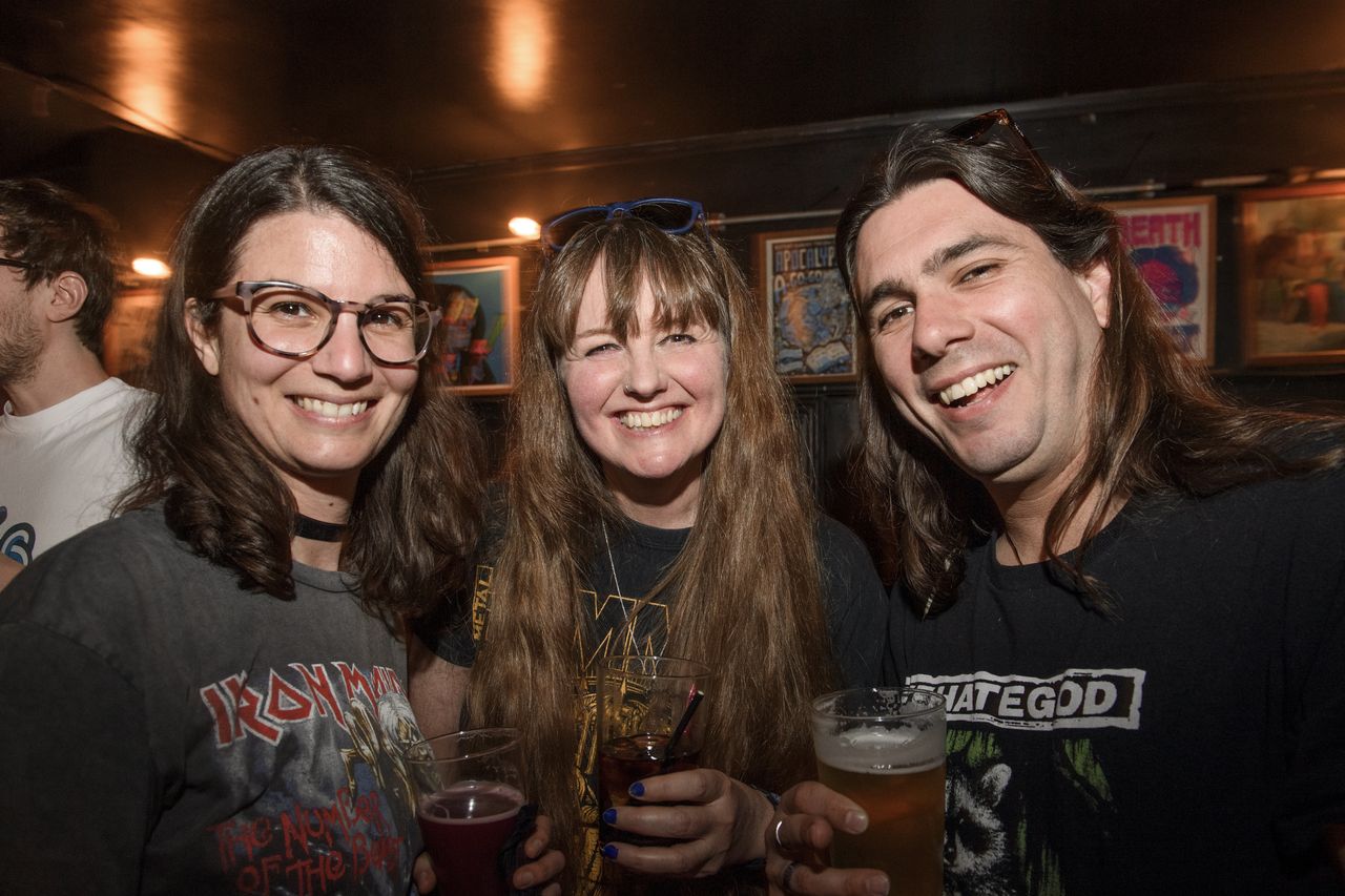 People drinking, smiling and throwing horns at the Metal Hammer 400 party