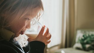 little girl drinking a glass of milk