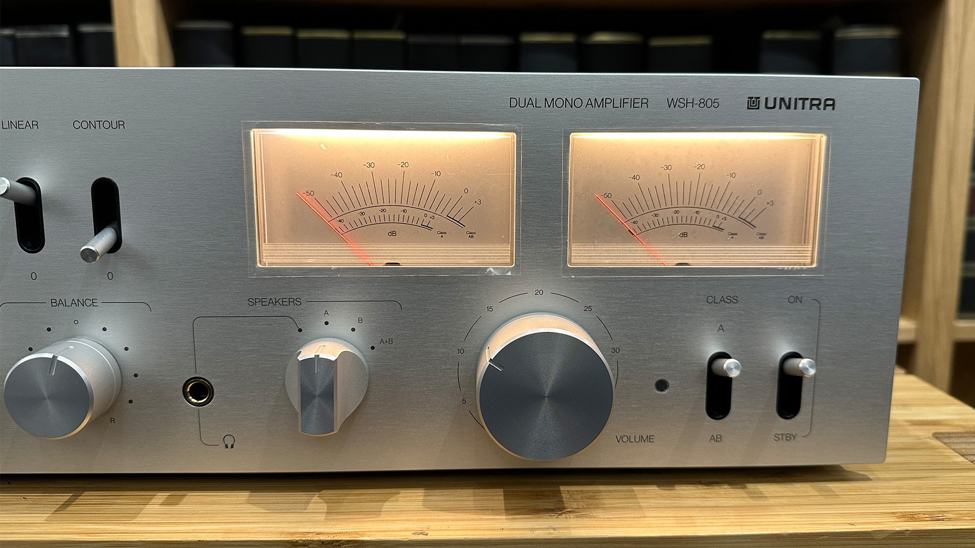 Unitra WSH-805 integrated amplifier on wooden hi-fi rack in front of bookcase close up on VU meters