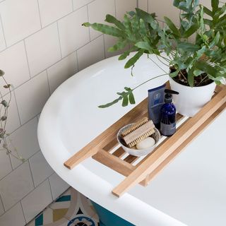 small white tile with bathtub and wooden bathtub tray