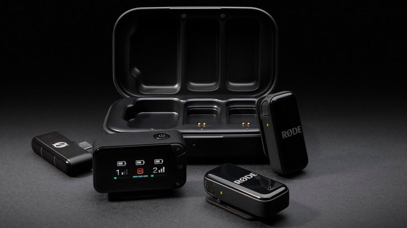 A RØDE Wireless GO II dual-channel microphone system, including two clip-on transmitters, the receiver unit with an LCD screen, and a charging case, is displayed on a black background.