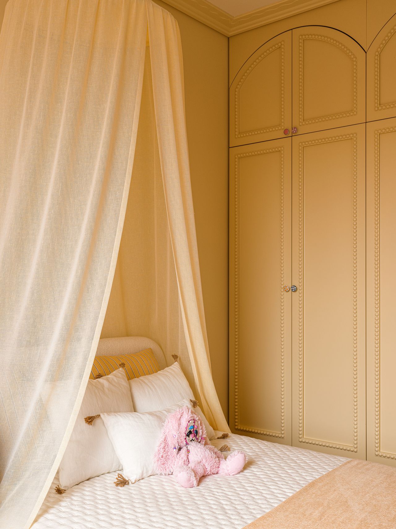 A bedroom painted a creamy shade of yellow