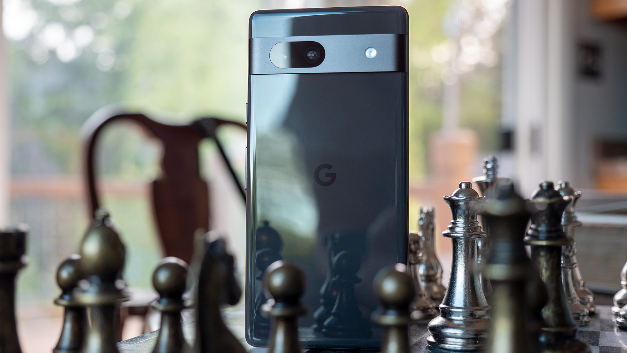 ظهر هاتف Google Pixel 7a الأسود على رقعة الشطرنج