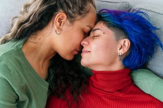 Two women lying down with their faces close together