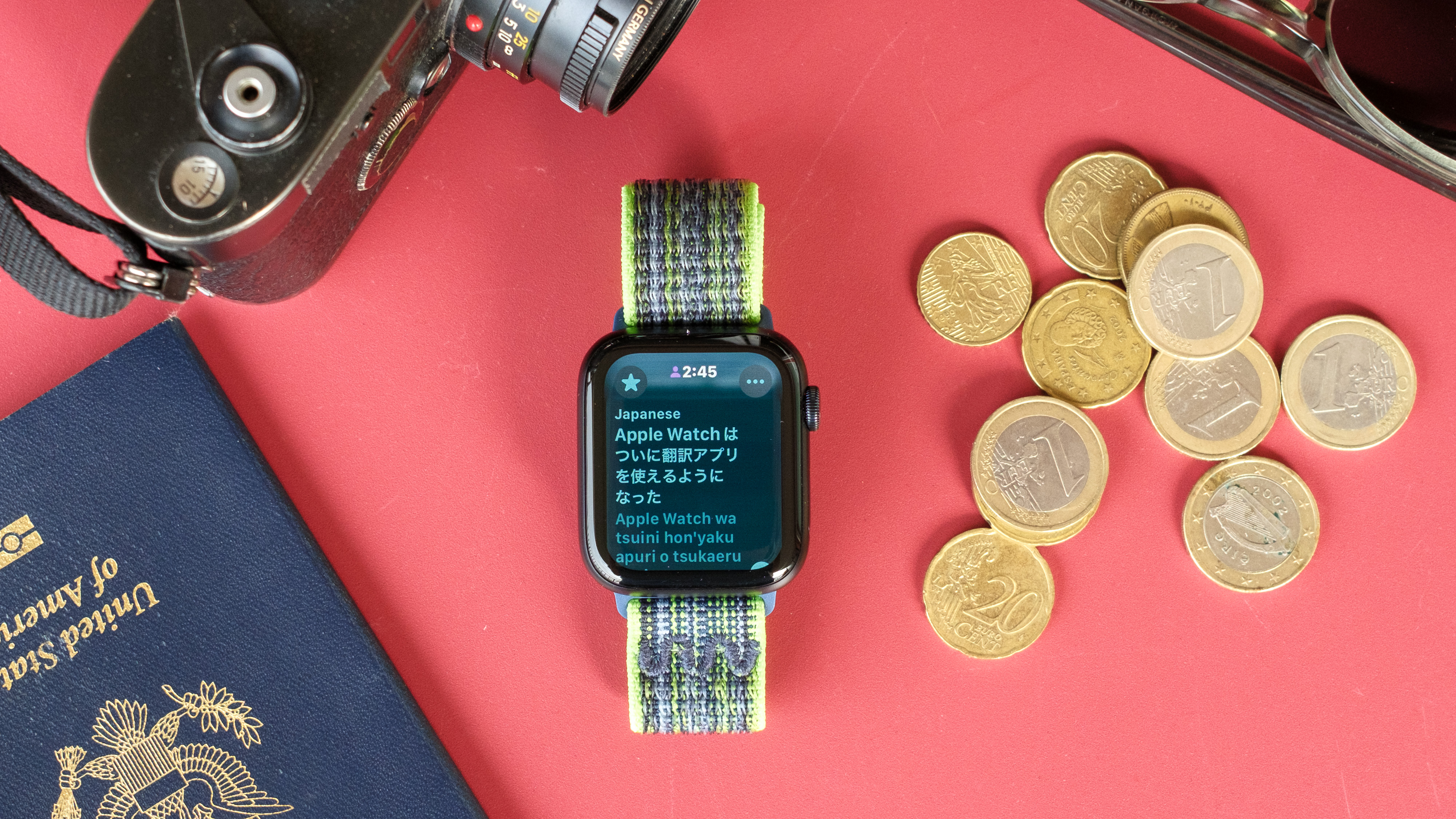 Close-up photo of the Apple Watch SE 2022 against a red background with the new Translator app on the screen.