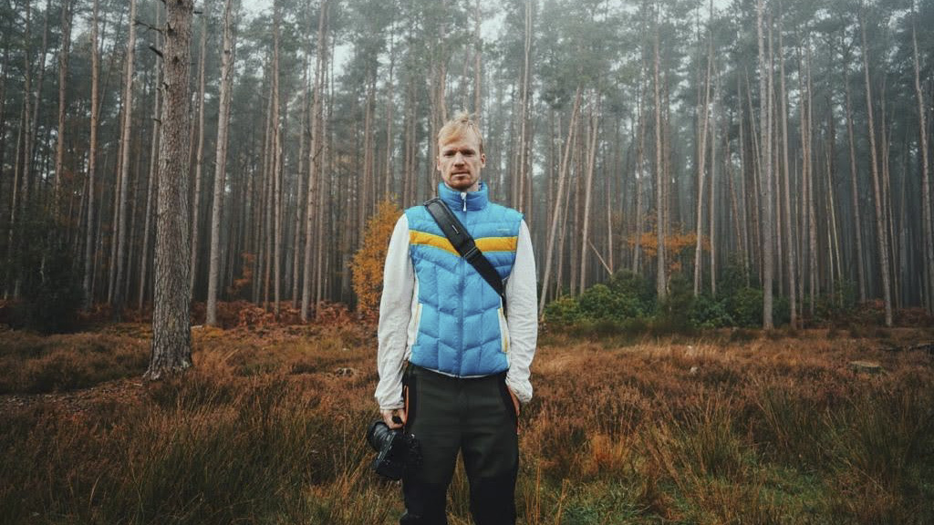 Photographer with a camera in a misty woodland