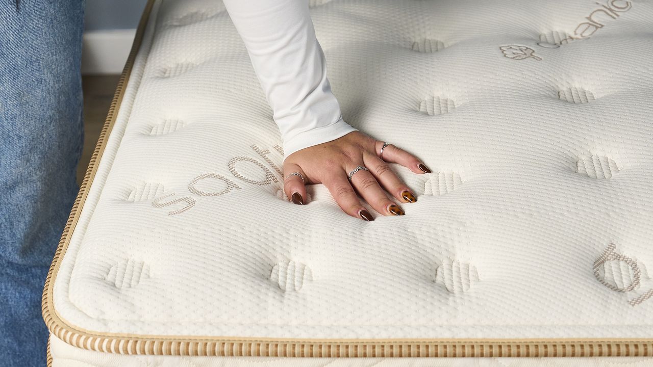 One of our review team places her hand on top of the Saatva Classic mattress during a temperature control test