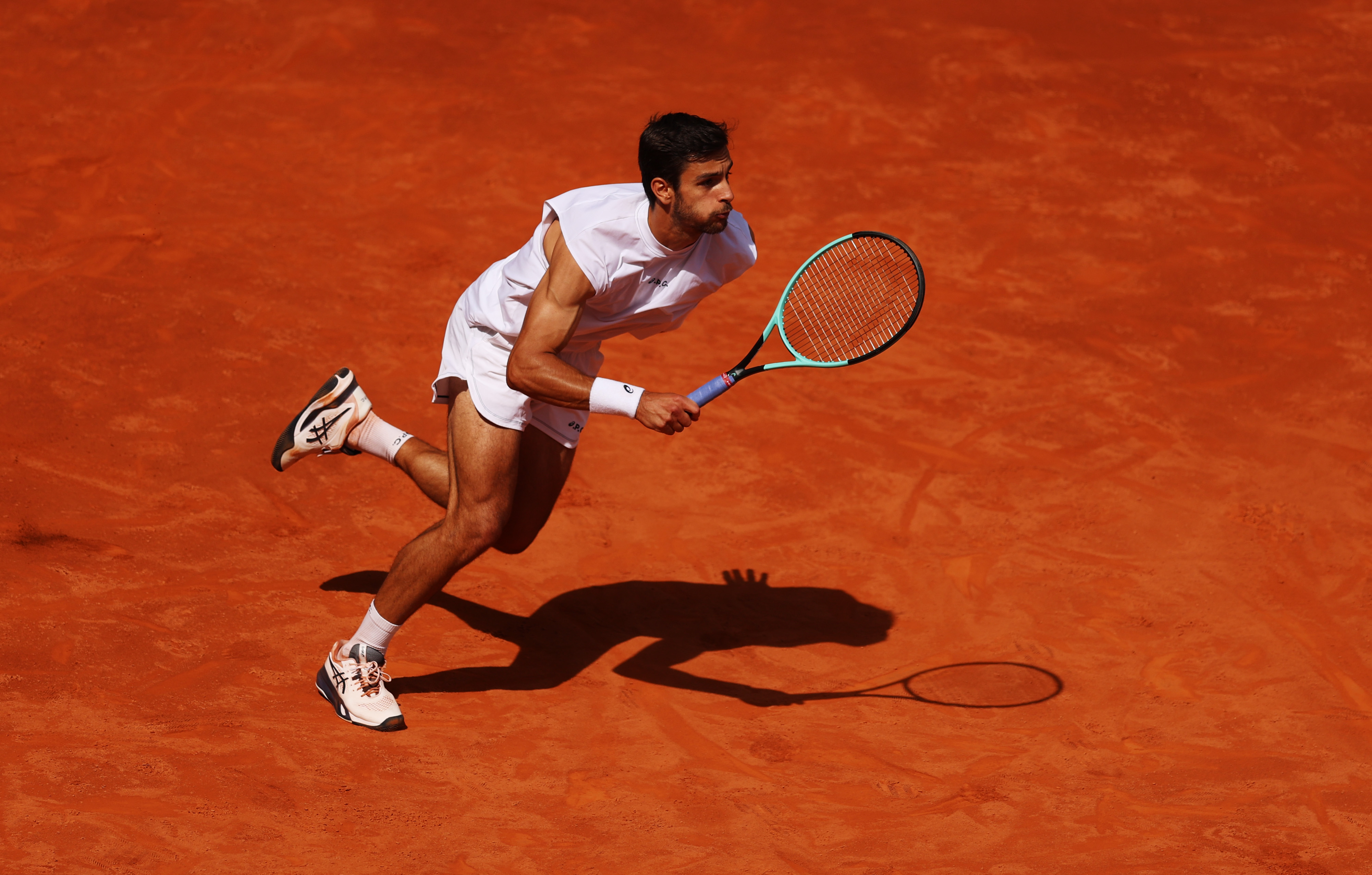 Lorenzo Musetti of Italy runs into the net during his match against Stefanos Tsitsipas of Greece at La Caja Magica in Madrid, Spain