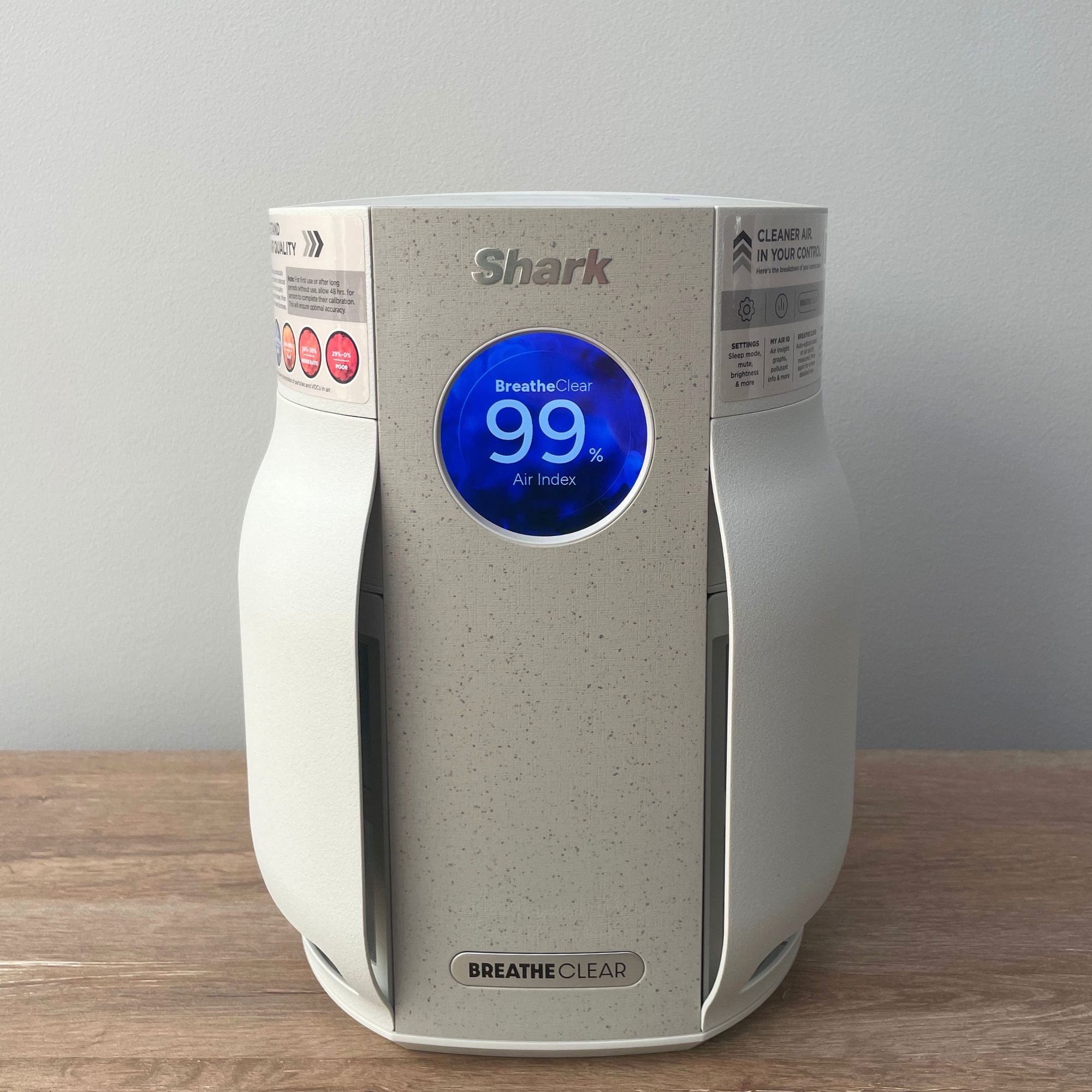 Shark BreatheClear Compact Air Purifier with NeverChange6 sitting on a wooden unit in front of a grey wall