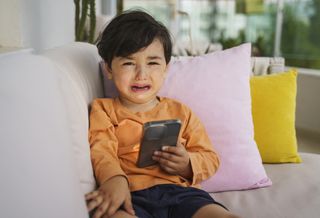 Child crying because doesn't want to give the phone back