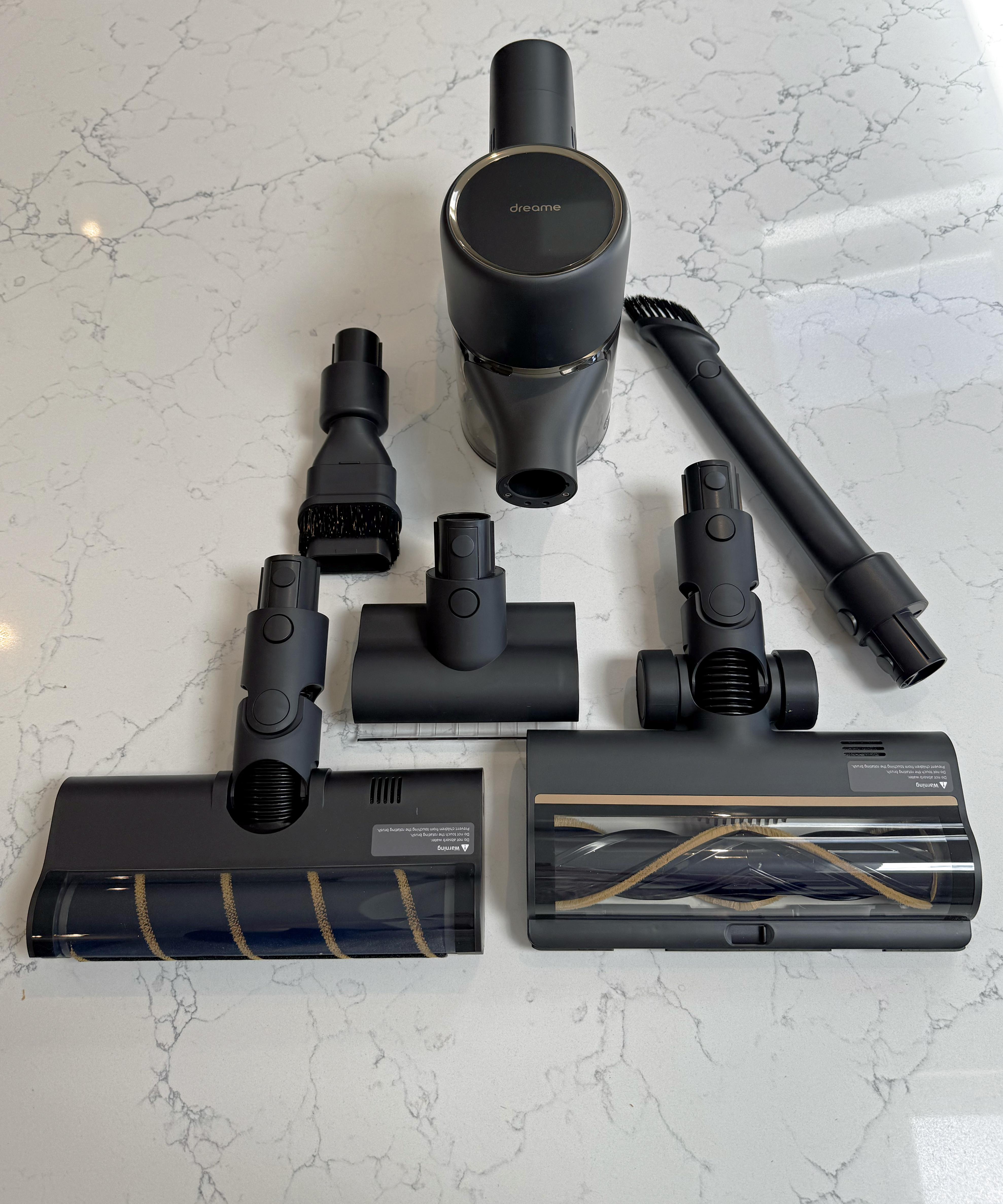Overhead flatlay of the Dreame R10 Pro vacuum body, both floorheads and smaller attachments