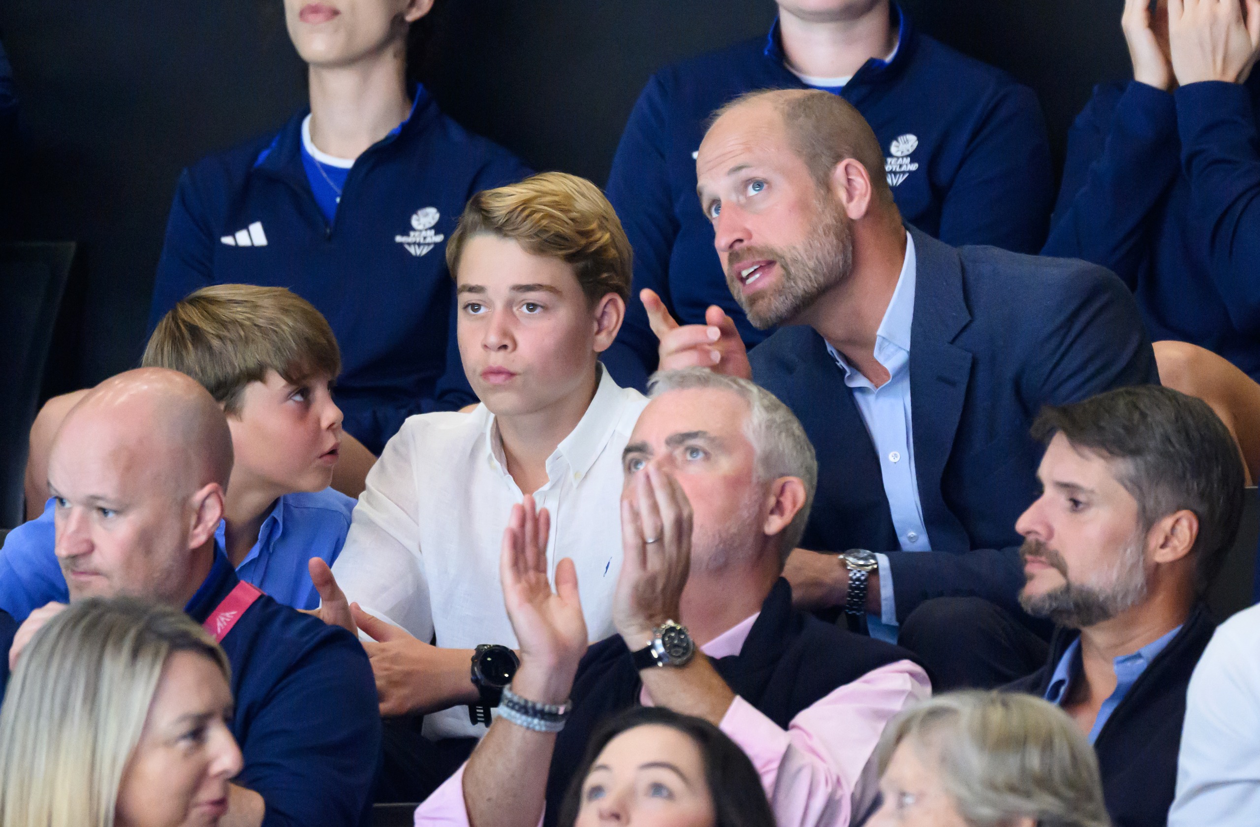 Prince William talking to Prince George and Prince Louis at the Commonwealth Games stands