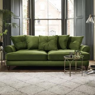 A green sofa in a grey living room