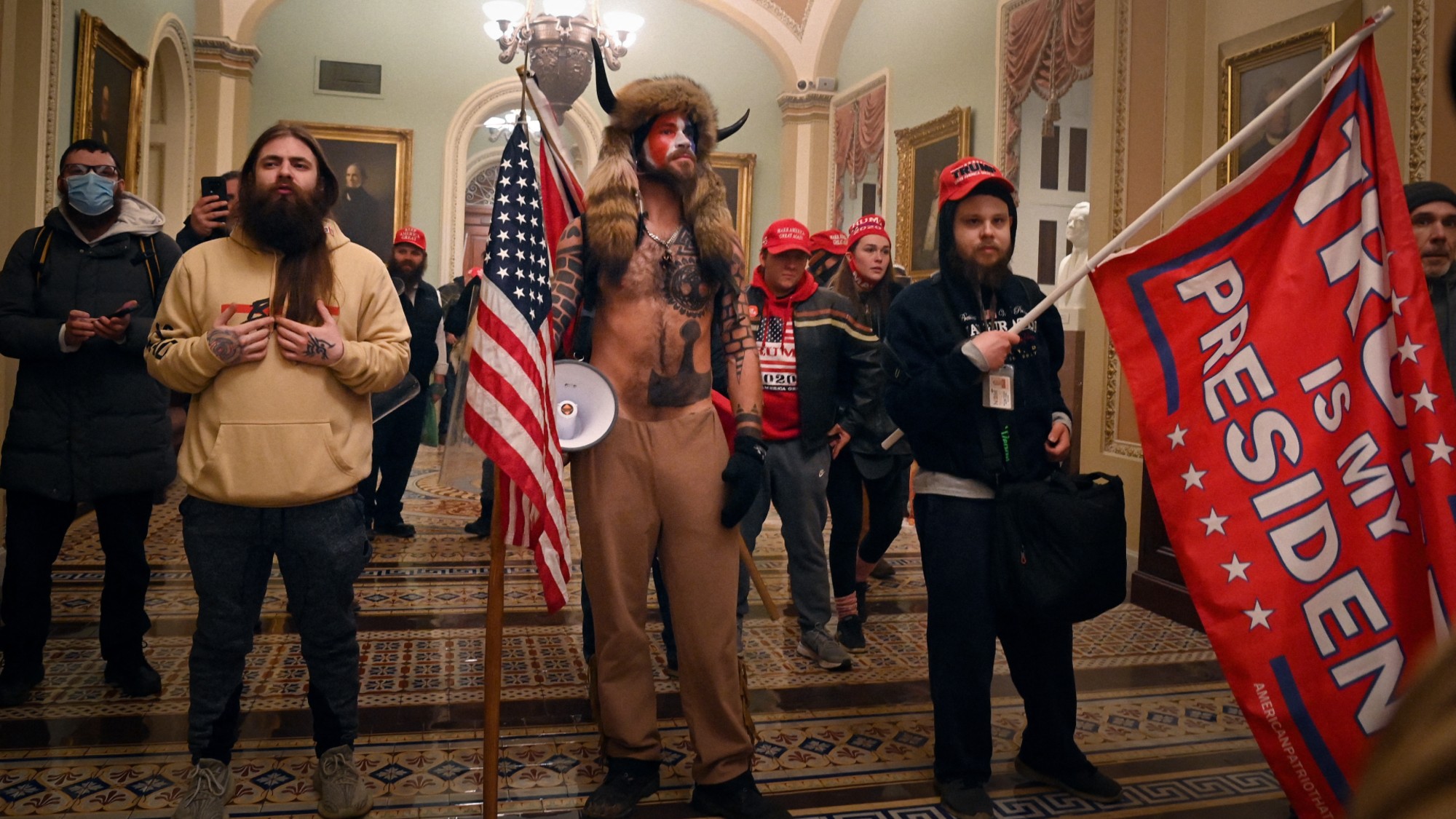 TOPSHOT - Supporters of US President Donald Trump, including member of the QAnon conspiracy group Jake Angeli, aka Yellowstone Wolf (C), enter the US Capitol on January 6, 2021, in Washington, DC. Demonstrators breeched security and entered the Capitol as Congress debated the a 2020 presidential election Electoral Vote Certification. (Photo by Saul LOEB / AFP via Getty Images)