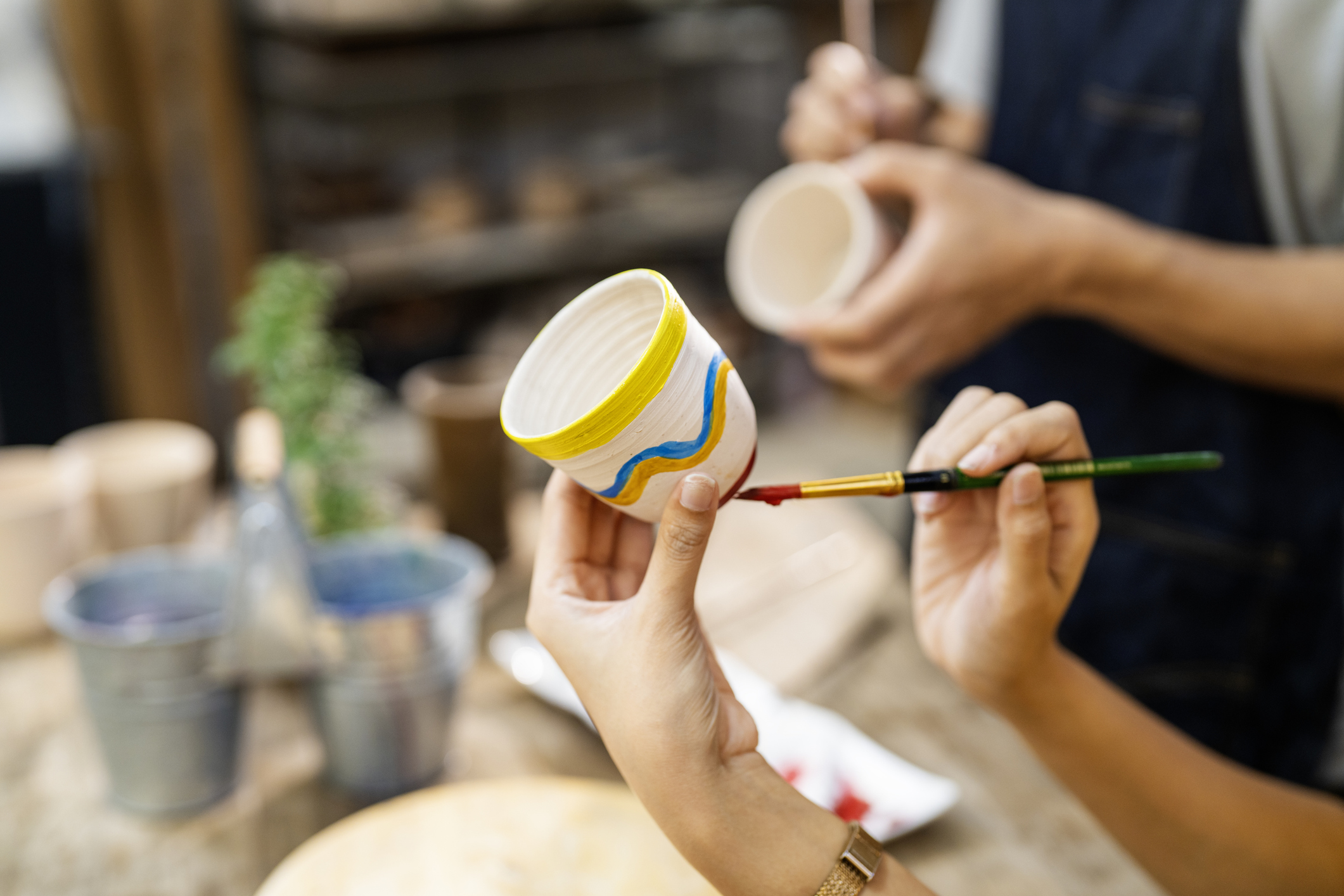 A person painting pottery.
