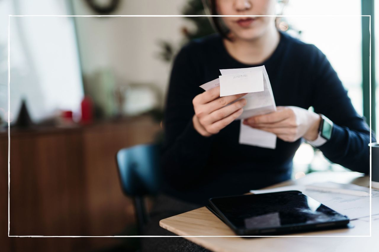 A close up of a woman looking at a pile of receipts 