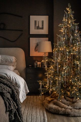 a christmas tree in a bedroom decorated with tinsel
