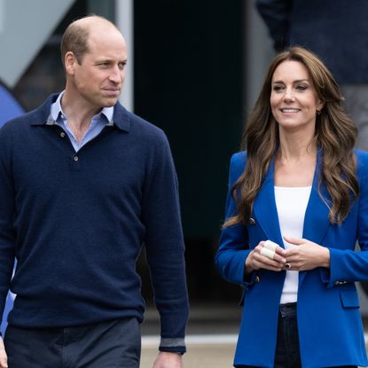 Prince William wears a blue sweater and shirt, and Kate Middleton wears a blue blazer and white T-shirt, while Princess Diana wears a blazer adorned with pearls