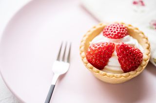 strawberry tart on a plate with a fork