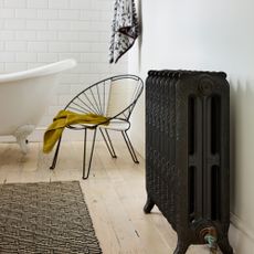 bathroom with black metal chair rug and white bath tub
