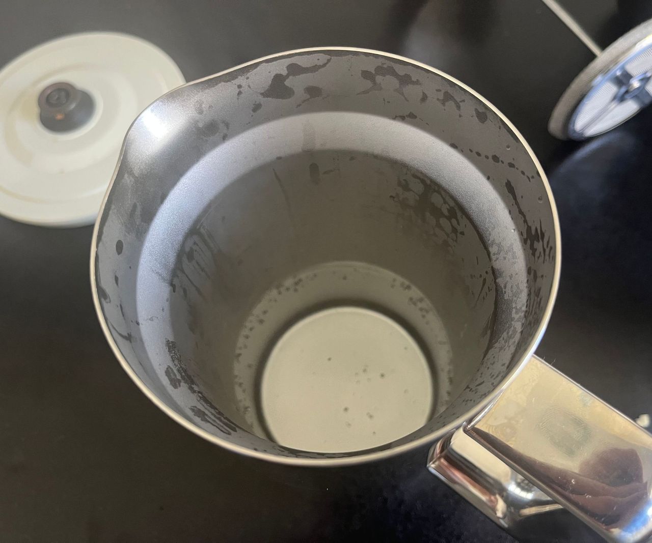 The steamed up interior of a stainless steel coffee press