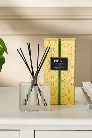 Nest New York Grapefruit Reed Diffuser on side with plant and books