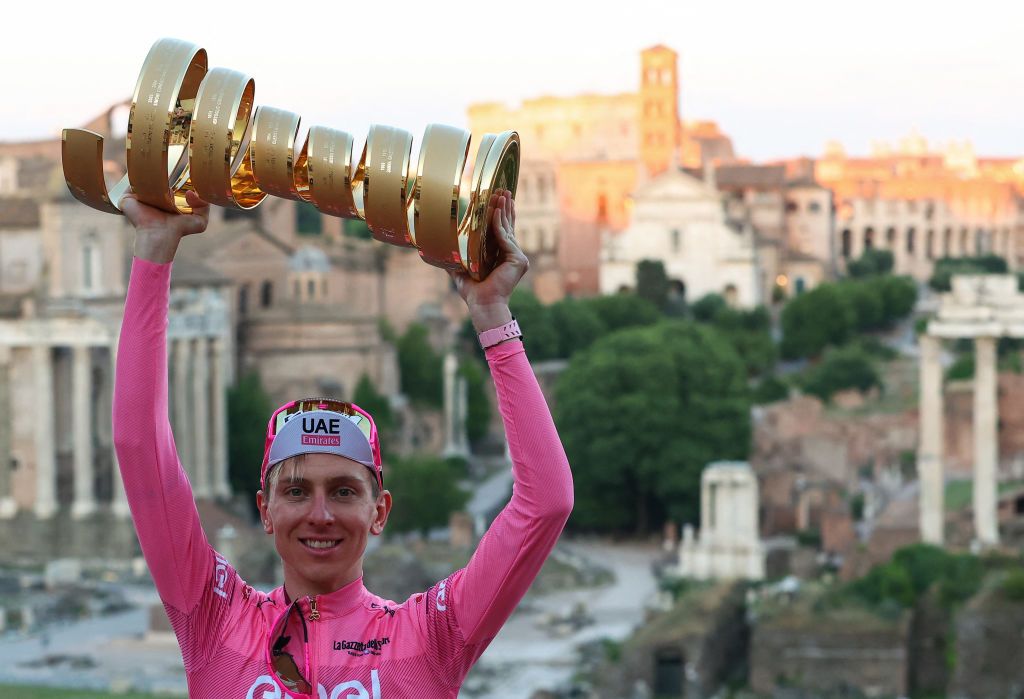 Team UAE&#039;s Slovenian rider Tadej Pogacar wearing the overall leader&#039;s pink jersey poses for photographs with the &quot;Trofeo Senza Fine&quot; (Endless or Infinity Trophy) in front of the Foro Romano (Roman Forum) after the 21st and last stage of the 107th Giro d&#039;Italia cycling race, 125km from Rome to Rome on May 26, 2024. (Photo by Luca Bettini / AFP)