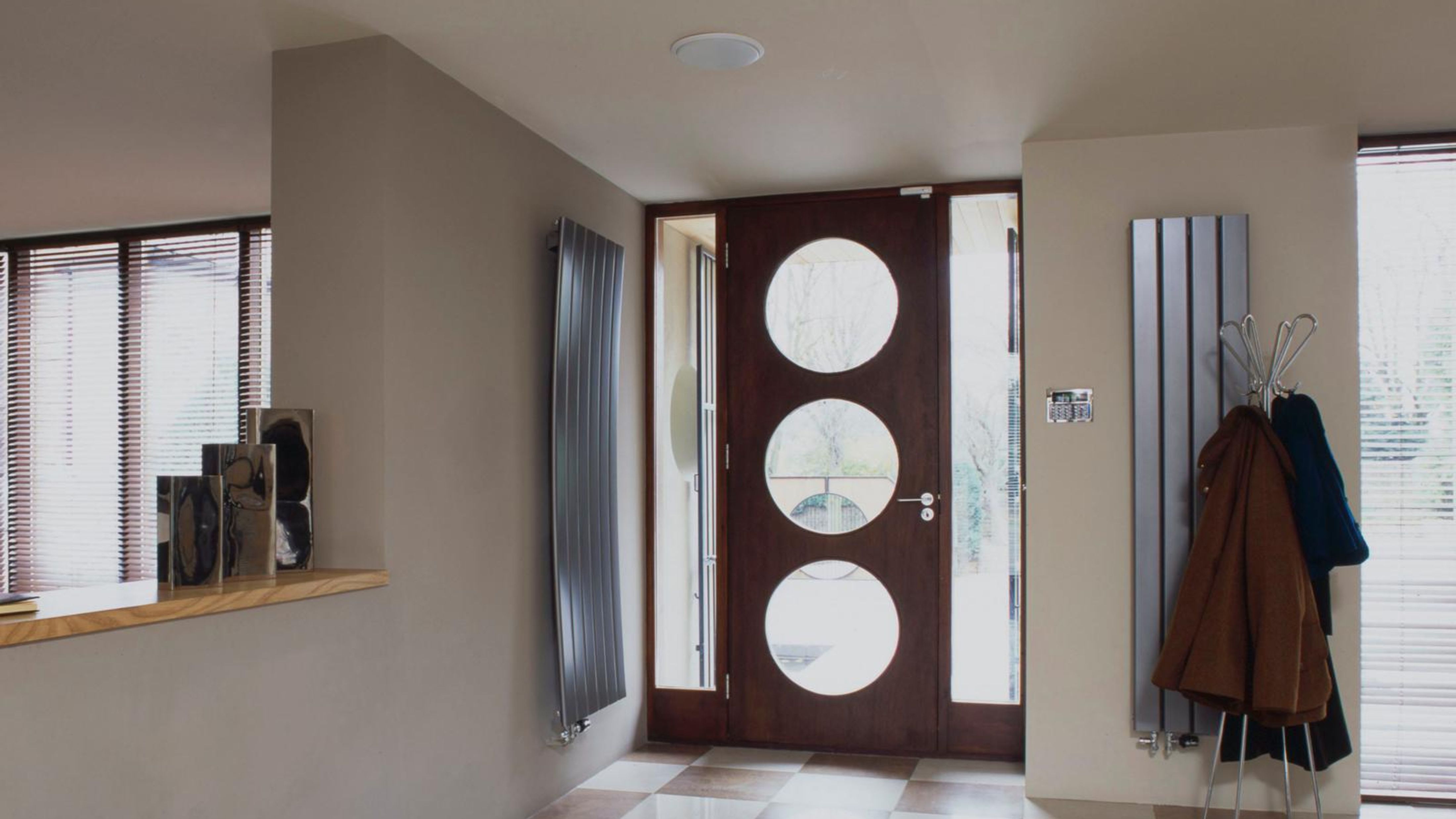 Mid-century-style entryway featuring a decorative glass-and-wood circle cut-out door and recessed ceiling light