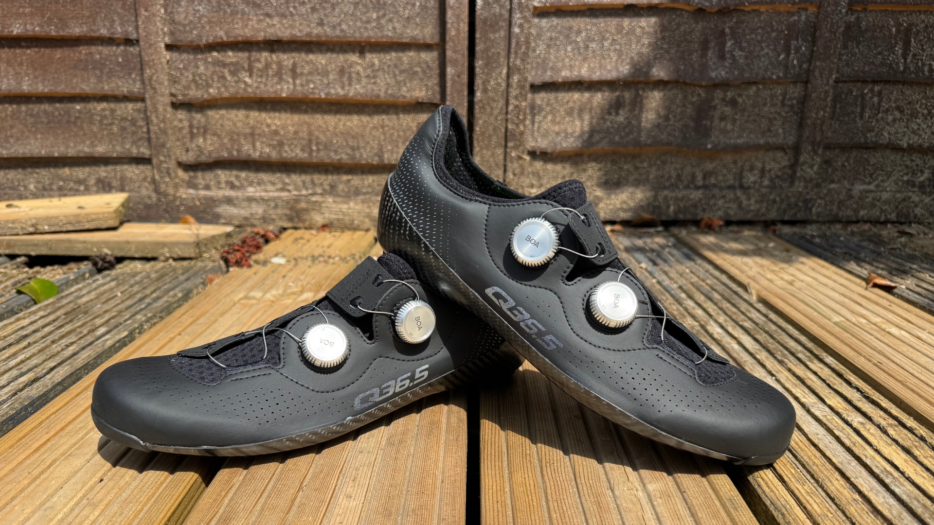 The Q36.5 Unique Pro shoes in black on wooden decking