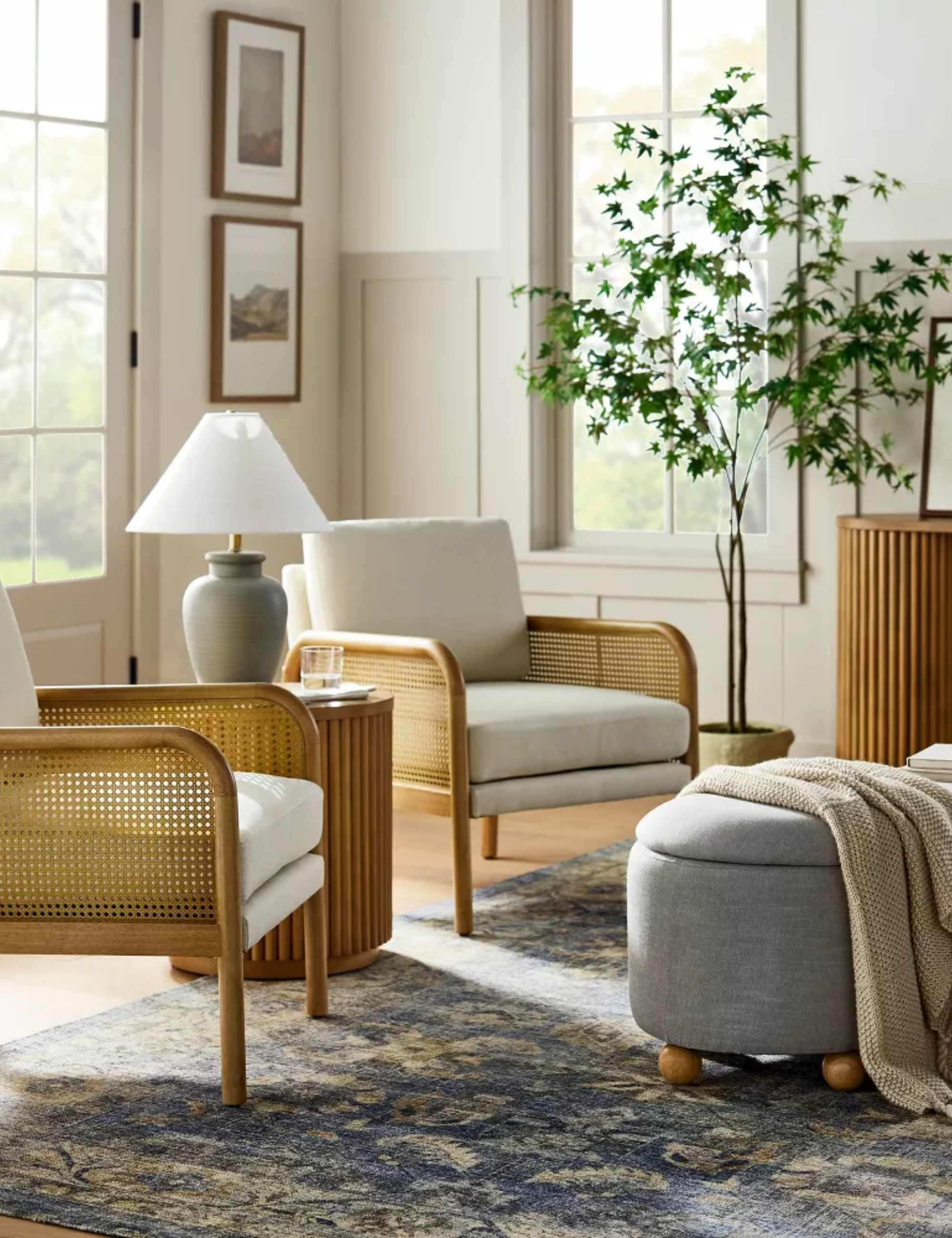Traditional cozy living room by Shea McGee for Target styled with mid-century-inspired cane-accent chairs and a blue tapestry-inspired rug