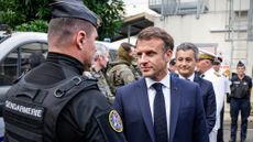 French President Emmanuel Macron greets police in New Caledonia