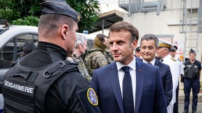 French President Emmanuel Macron greets police in New Caledonia
