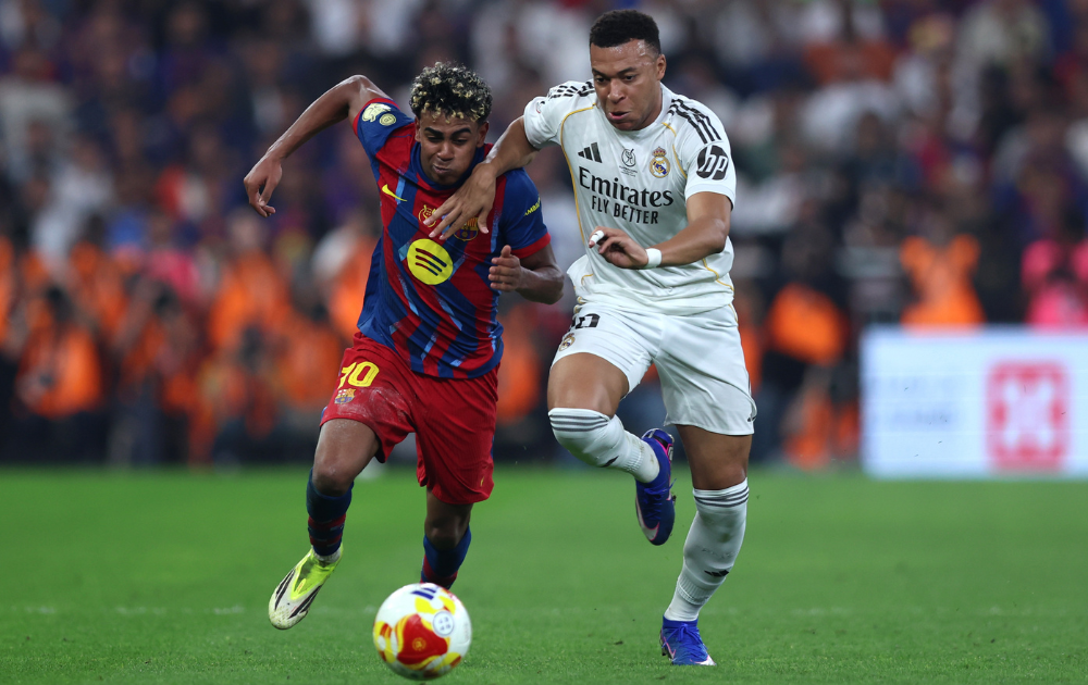 Kylian Mbappe of Real Madrid battles for possession with Lamine Yamal of FC Barcelona