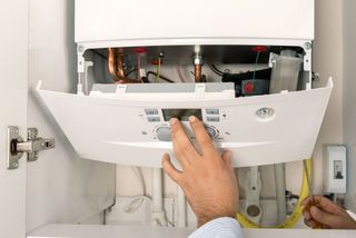 A gas combi boiler with the front exposed to reveal the controls inside