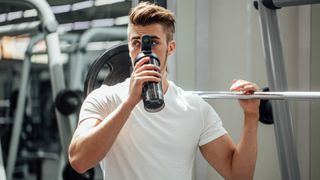 man drinking preworkout at the gym