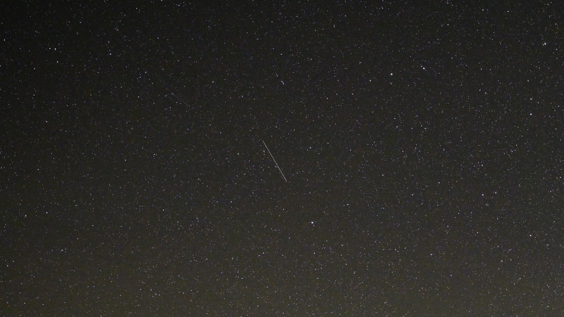 a streak of light against a starry night sky