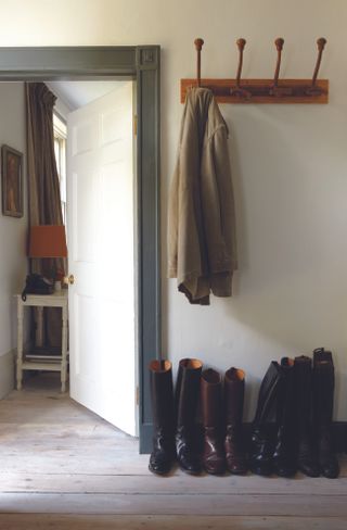 Light entryway with dark trims and boots lined up against the wall