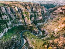 Aerial drone photo of Cheddar Gorge, Somerset UK. Taken at sunrise to capture the warmth of the light coming through the gorge and light on the rocks