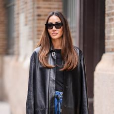 best hair conditioners - Tamara Kalinic wears sunglasses, a long black leather jacket , a black t-shirt, blue flared denim jeans pants, a black leather bag - getty images 2018040848