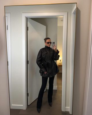 Sophie wears an eaves coat and black pants.