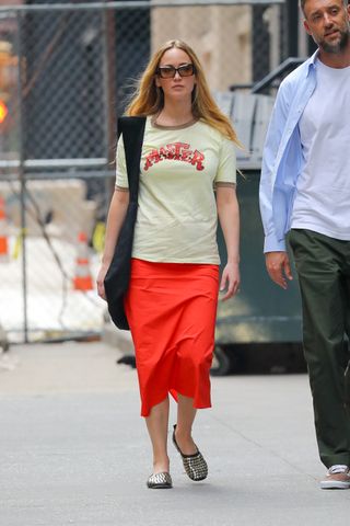 Jennifer Lawrence wearing a graphic T-shirt, red maxi skirt, and Tory Burch studded ballet flats in NYC