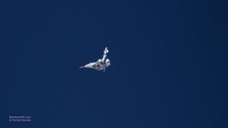 Virgin Galactic's SpaceShipTwo Unity's tail boom is seen in its "feathered" position to maintain stability during its descent in a successful rocket-powered test flight on May 29, 2018 over California's Mojave Desert.