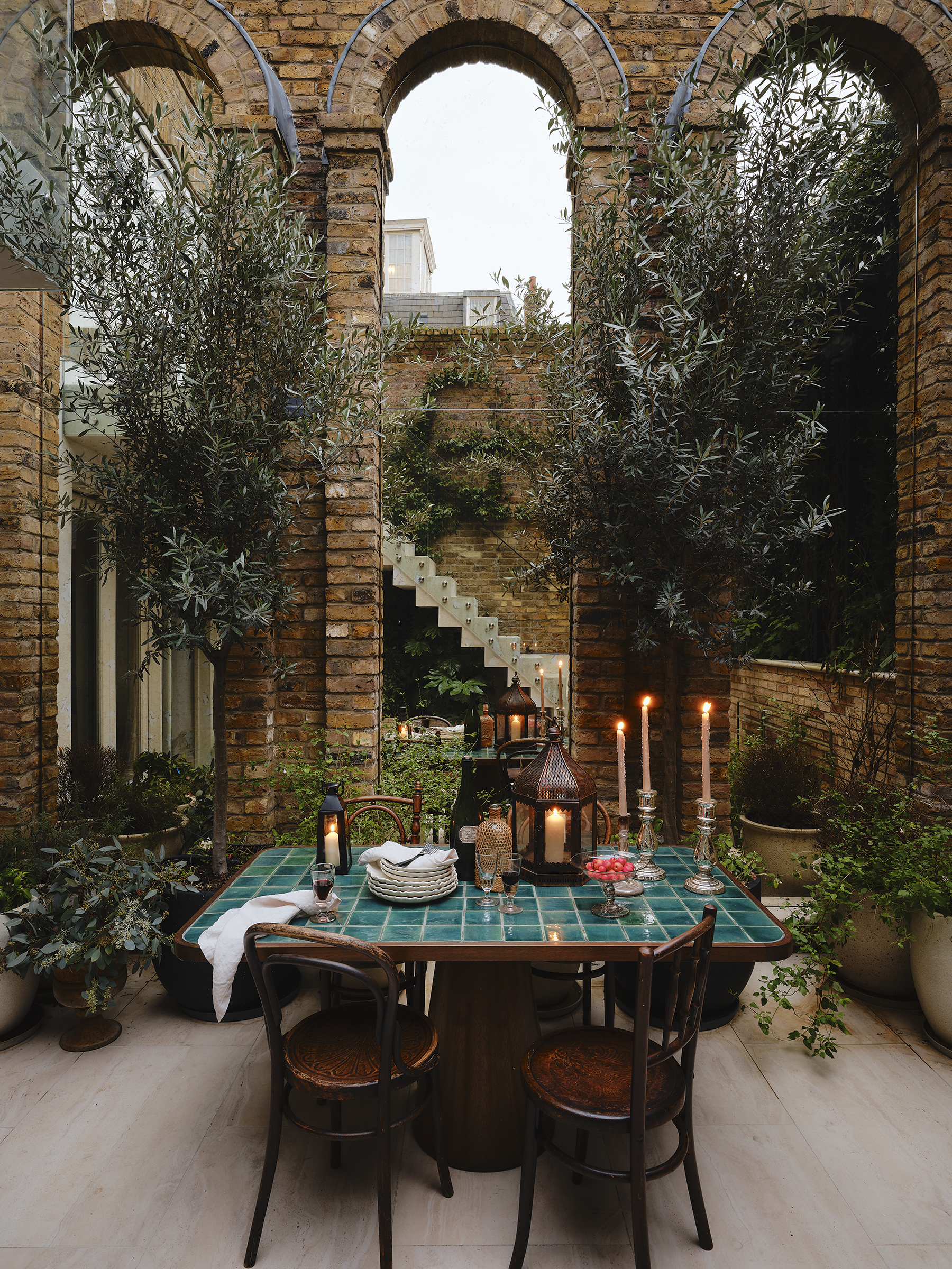 tile candlelit table with brick pillars and plants