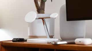 Belkin BoostCharge Pro 3-in-1 Wireless Charger surrounds by Apple products on a wooden desk